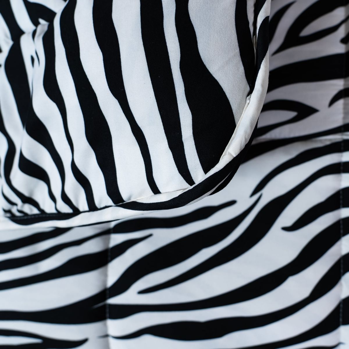 Gros plan sur la couette et l'oreiller Zelesta Wonderbed Light - Peau de Zèbre, qui présentent un imprimé zébré noir et blanc et sont fabriqués en microfibre thermorégulatrice rafraîchissante, idéale pour une couette d'été.