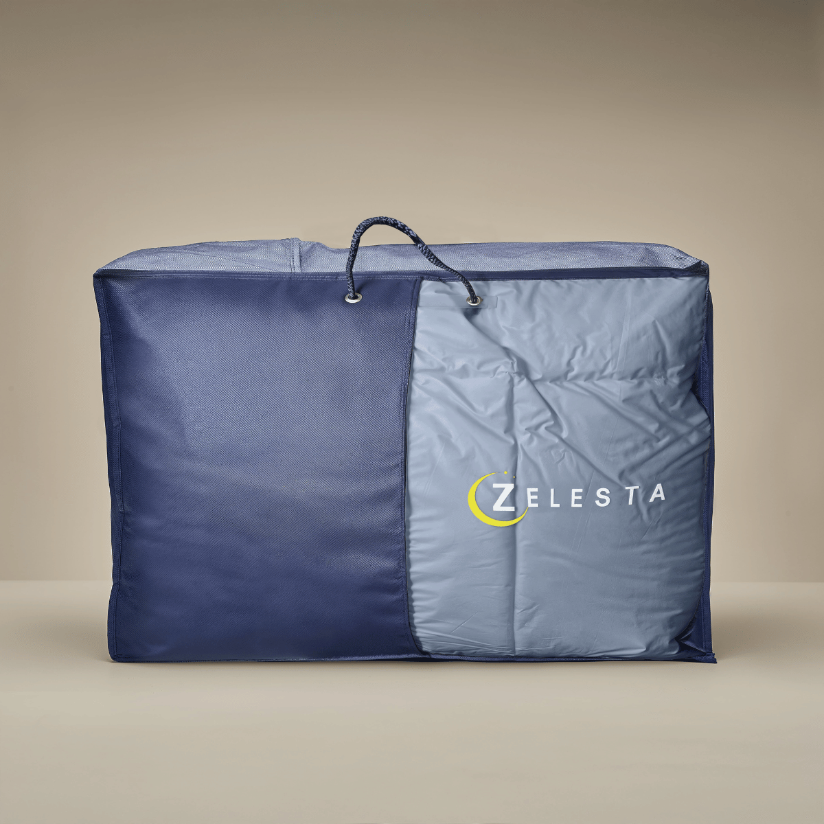 Un sac spacieux en tissu bleu et gris avec fermeture éclair et poignée, idéal pour ranger votre Zelesta Premiumbed Light Coton - Bleu Rêve & Crème, avec le logo ZELESTA sur le devant.