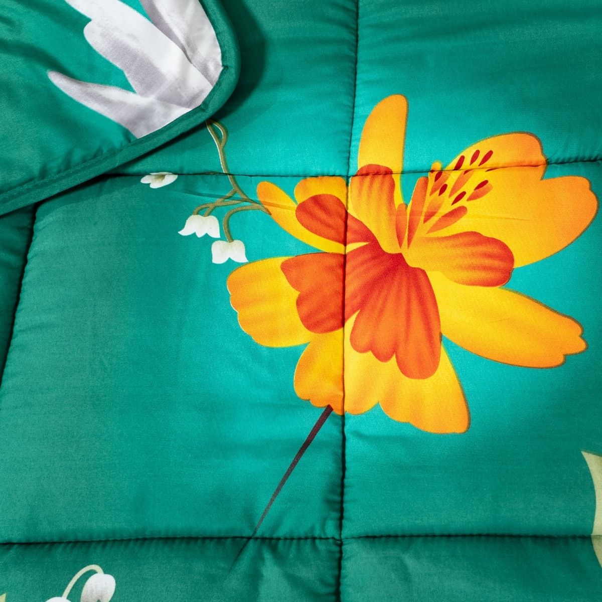 La couette lavable Zelesta Wonderbed - Fleurs de Printemps est une couette en microfibre de couleur sarcelle avec de grandes fleurs jaune-orange, des fleurs blanches et des coutures piquées. Cette couette lavable est anti-allergène pour plus de confort.