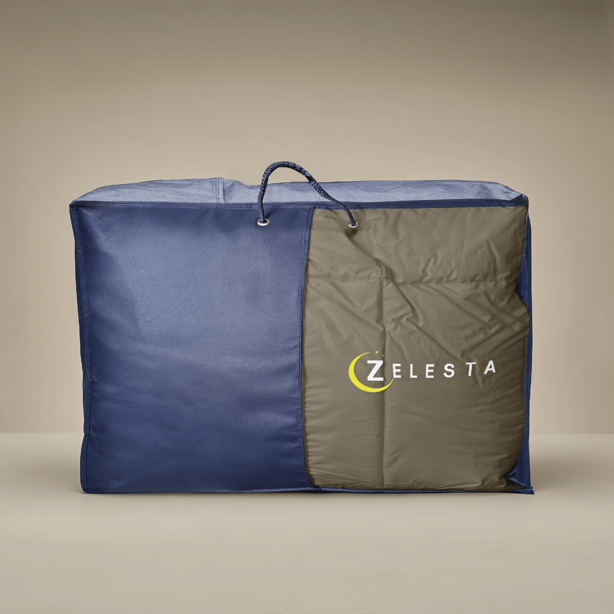 Un sac de rangement spacieux en tissu taupe et crème avec fermeture éclair, poignée et logo ZELESTA, idéal pour ranger votre couette Zelesta Premiumbed Light Coton.