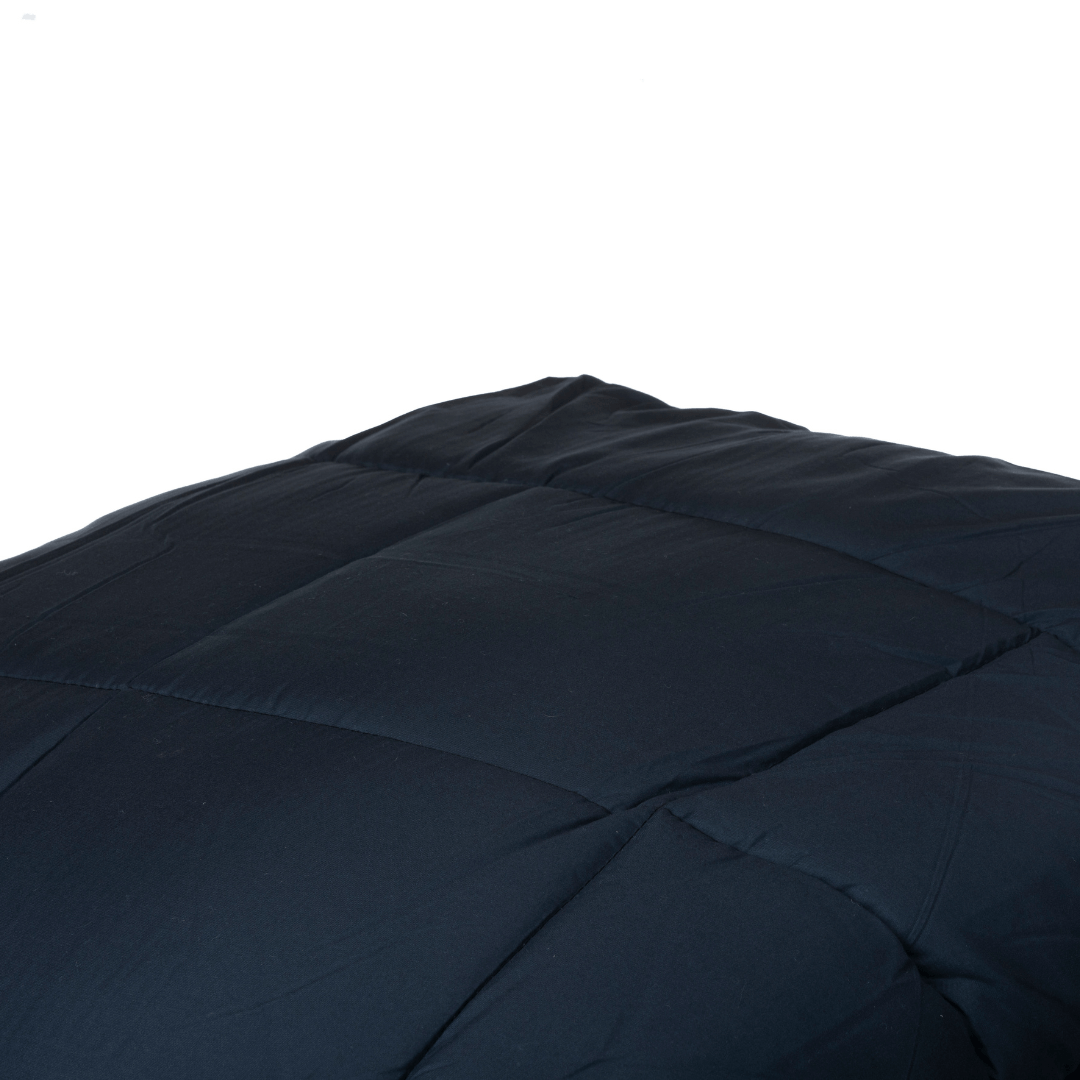 Gros plan sur le lit magique Zelesta - Anthracite, dont la surface matelassée foncée présente une texture luxueuse rappelant la microfibre haut de gamme, sur un fond blanc impeccable.