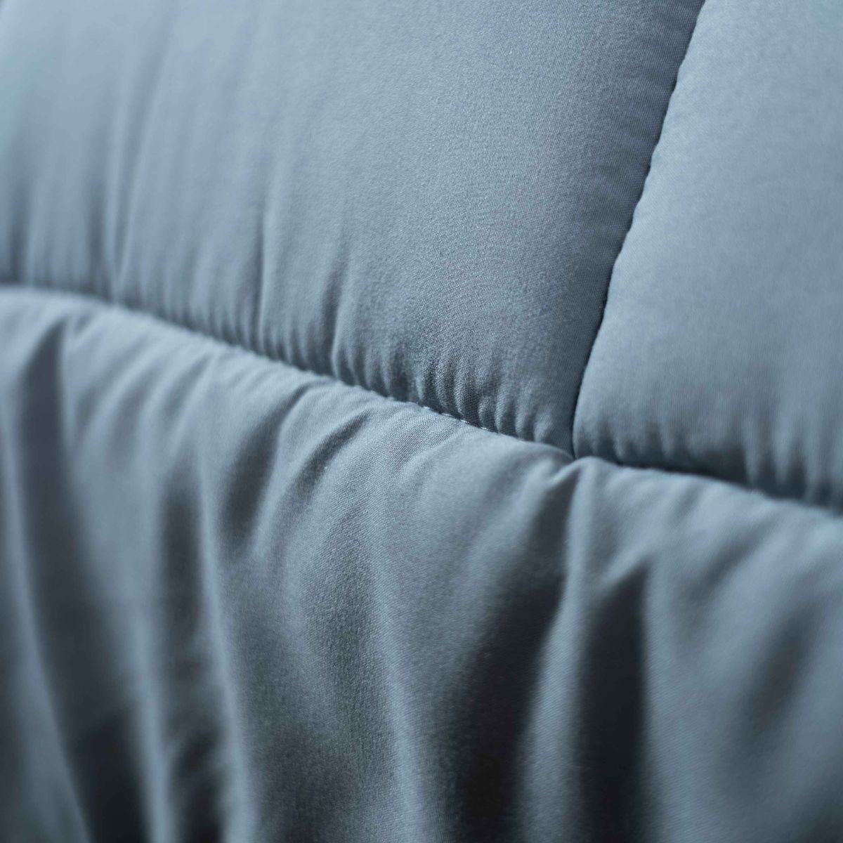 Gros plan sur le tissu matelassé en microfibre Syndonfill de Zelesta Wonderbed - Gris, avec des coutures visibles et des sections rembourrées pour une couette douce, durable et anti-allergène - un confort parfait pour les dormeurs sensibles.