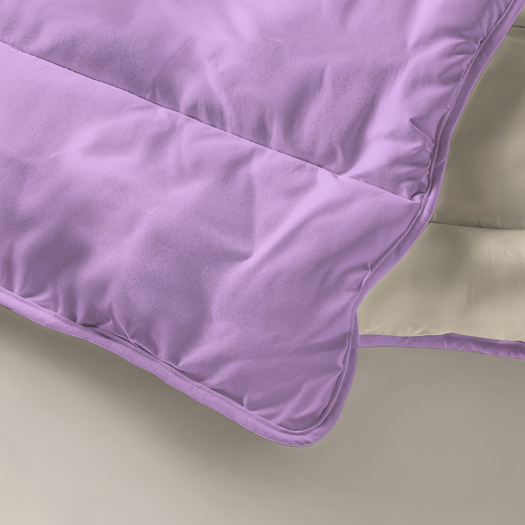 Un gros plan du Zelesta Royalbed - Lilas & Plage de Sable montre son dessus violet, son dessous beige, sa texture douce et les détails des coutures.