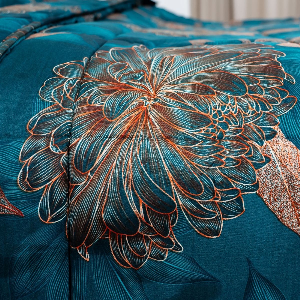 Gros plan sur le tissu sarcelle du lit magique Zelesta Wonderbed Light - Fleurs Royales, qui présente un motif floral orange et blanc complexe avec des coutures et une texture détaillées.