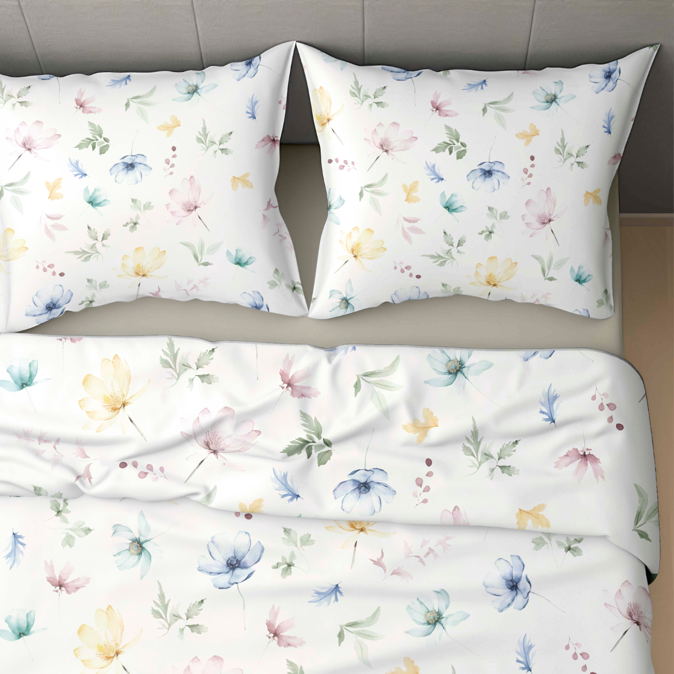 Des draps de lit blancs et deux oreillers avec un imprimé floral et de feuilles pastel en jaune, bleu, rose et vert complètent parfaitement le lit Zelesta Wonderbed 4 Saisons Double - Éclosion Printanière pour un confort tout au long de l'année.
