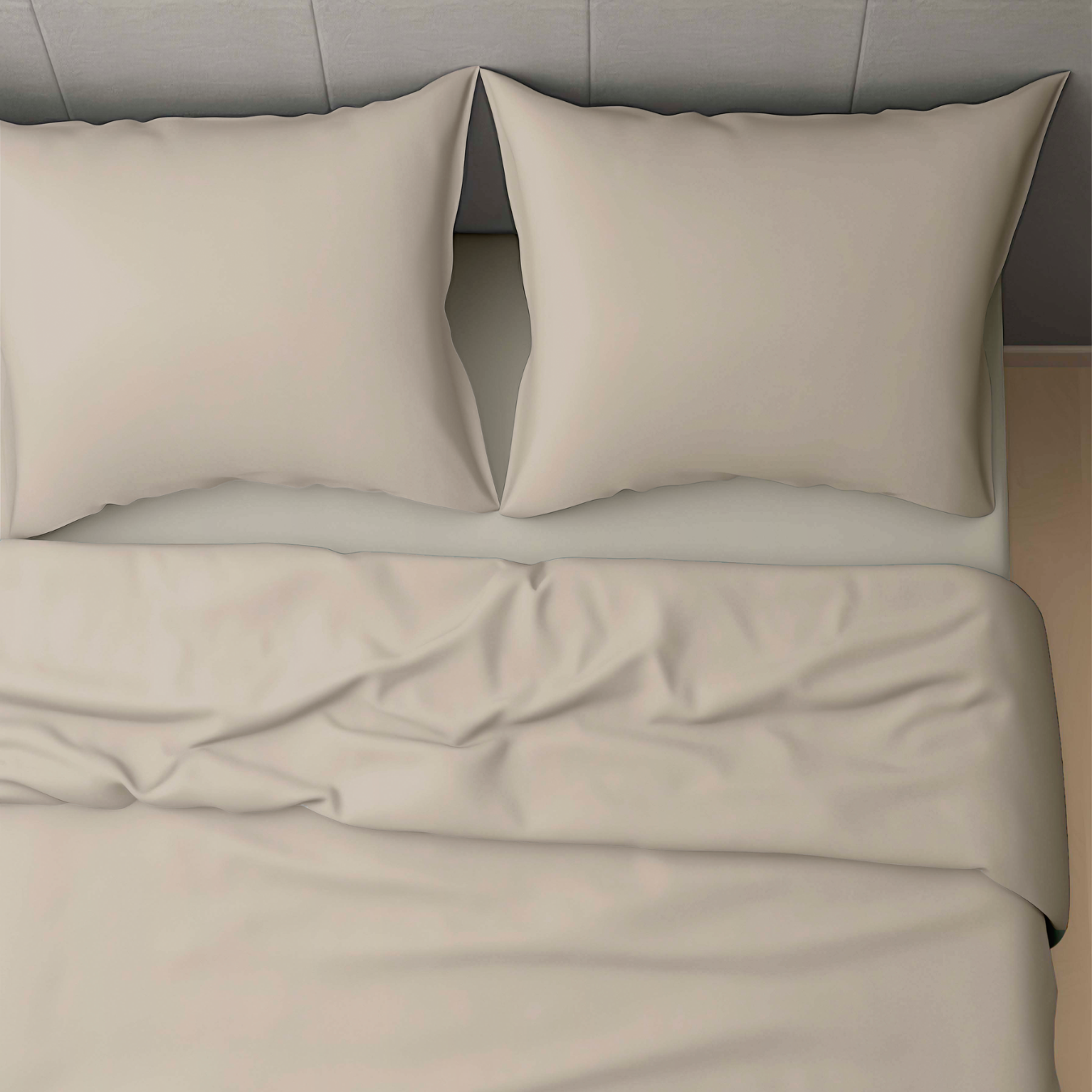 Vue de dessus d'un lit non fait avec deux oreillers et un drap et une couverture taupe légèrement froissés, mettant en valeur le Zelesta Wonderbed 4 Saisons Double Coton - Taupe Poudré pour un confort optimal tout au long de l'année.