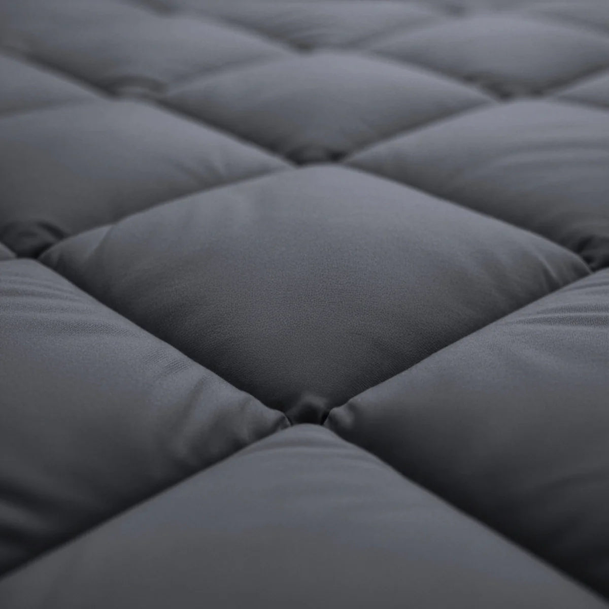Vue rapprochée d'un tissu matelassé gris foncé avec un motif bouffant et quadrillé, similaire au Zelesta Royalbed Diamant - Anthracite.