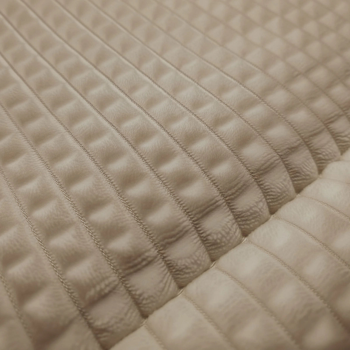 Gros plan sur Zelesta Teddy Check - Taupe : revêtement matelassé beige avec un motif en grille et une texture pelucheuse en relief pour un confort ultime.