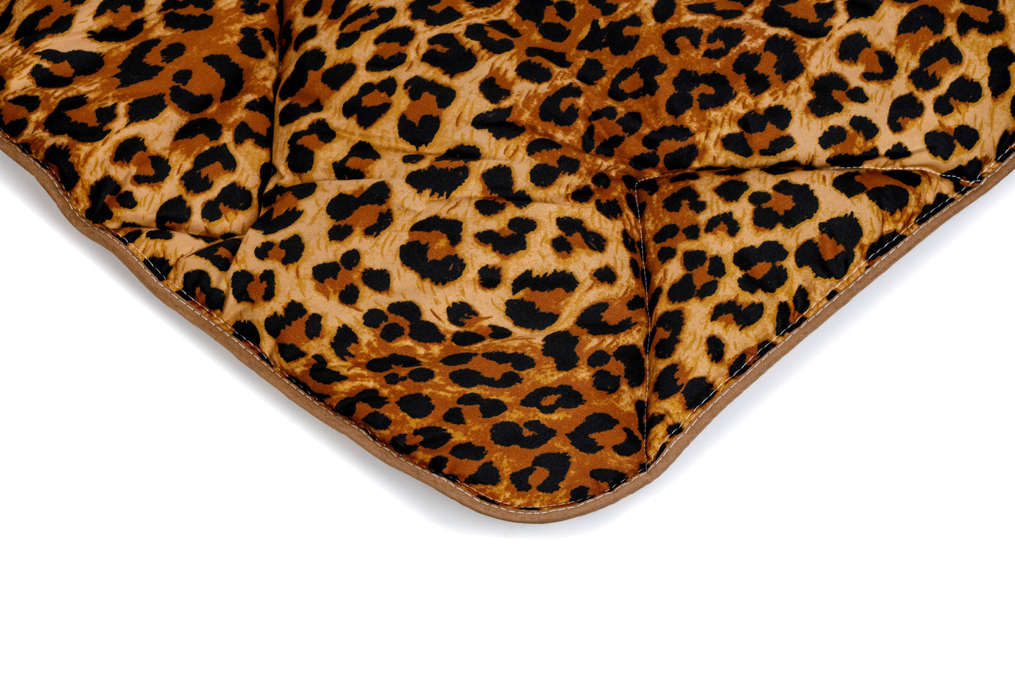 Gros plan de la couverture matelassée thermorégulatrice Zelesta Wonderbed Light - Peau de Jaguar, en microfibre, avec un imprimé jaguar marron et noir, sur fond blanc.