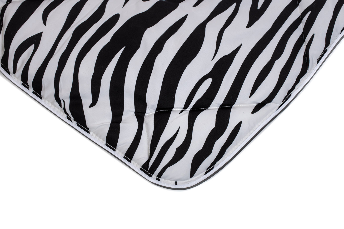 Gros plan sur le lit magique Zelesta - Peau de Zèbre, avec son tissu en microfibre à motif zébré noir et blanc, ses coins détaillés et ses bordures surpiquées.