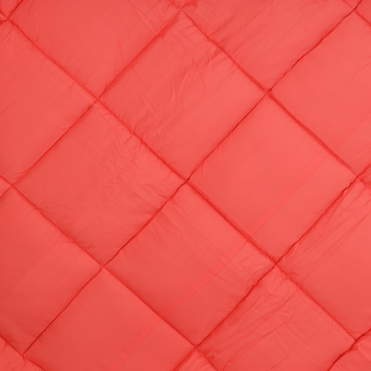 Le gros plan de Zelesta Easybed - Chocolat & Corail montre un tissu matelassé rouge avec un motif en losange et des coutures apparentes, idéal pour une couette microfibre ou une couette lavable.