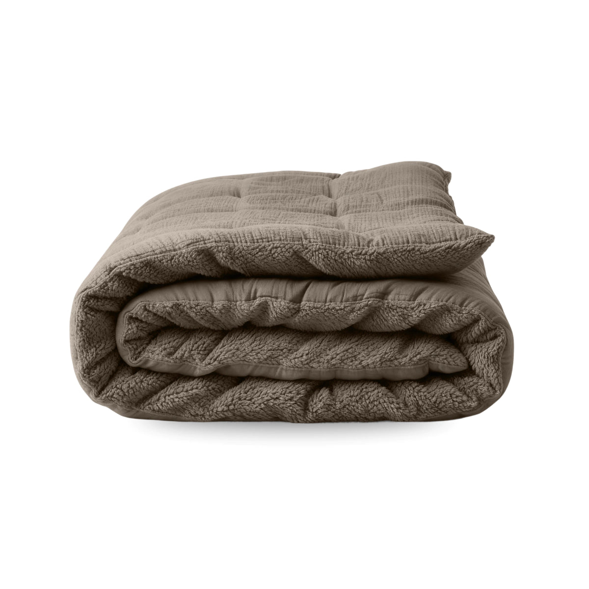 La couverture Zelesta Teddy Mousseline de Coton en taupe, au design matelassé et au tissu mousseline de coton doux, est présentée pliée sur un fond blanc uni.